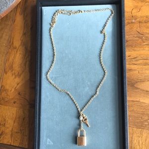 Gold necklace with lock and key hanging charm